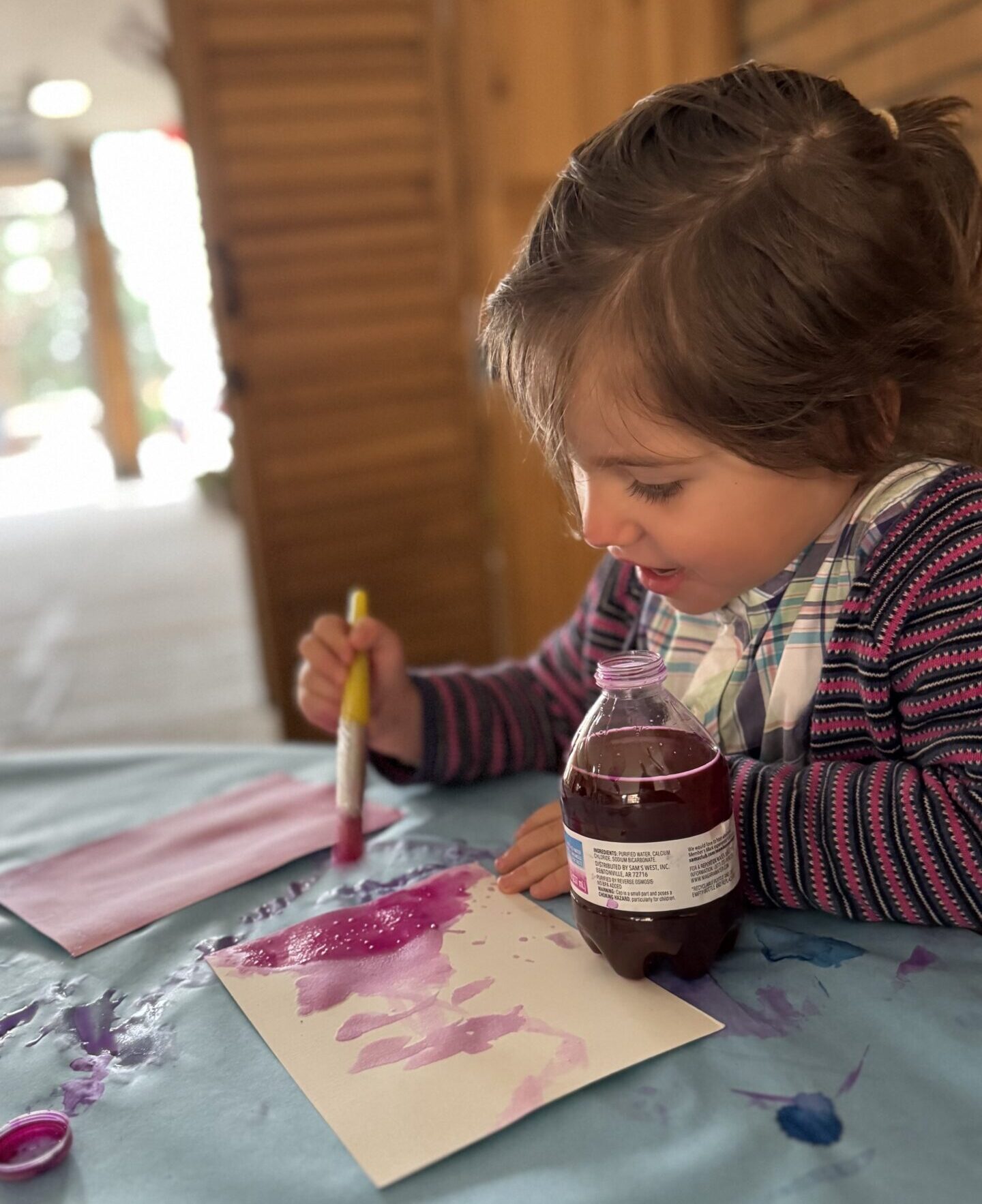 Young child painting and exploring art materials at First Pres Preschool