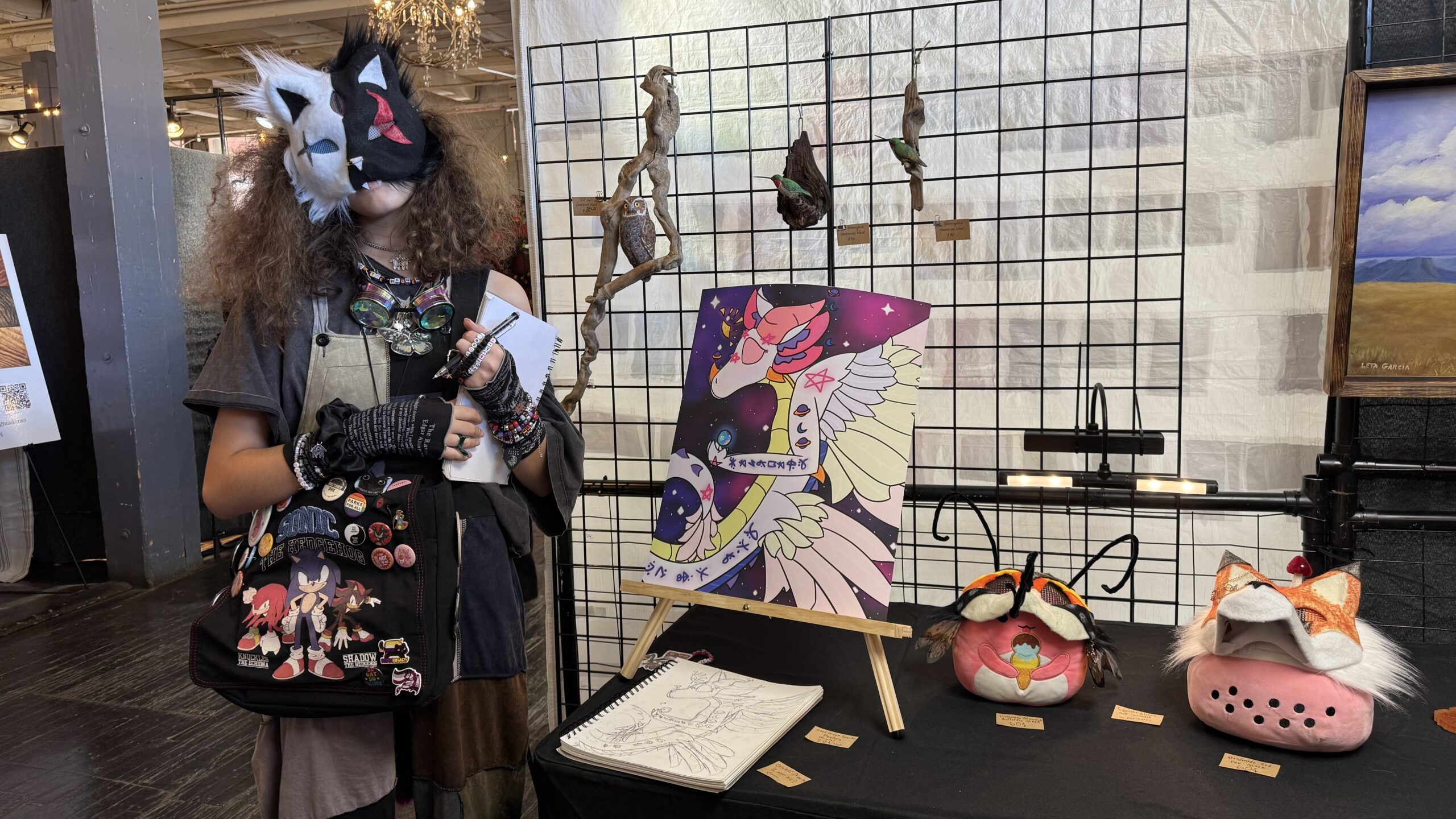 A First Pres student presenting handmade masks and artwork at a display