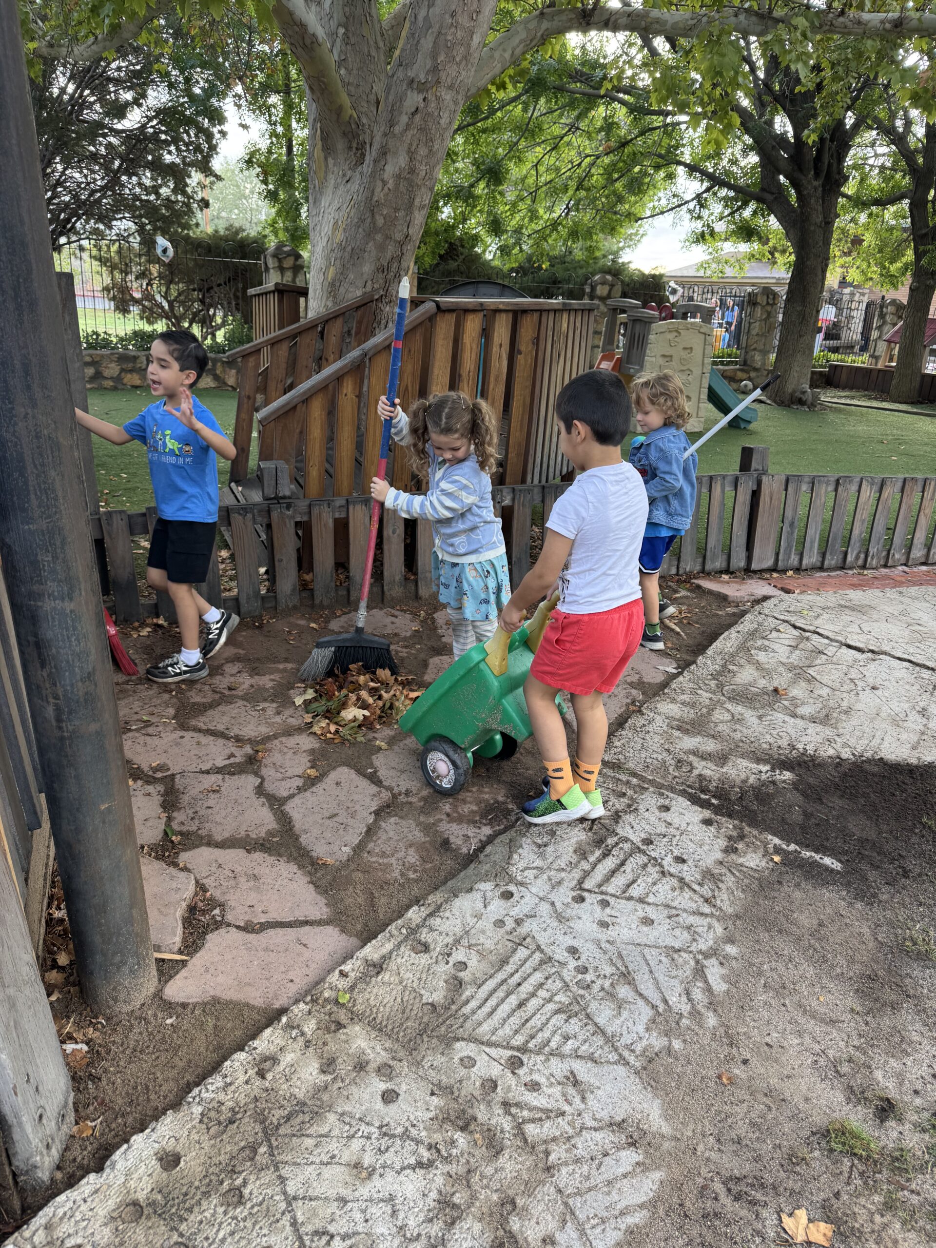 First-grade children playing together beneath trees