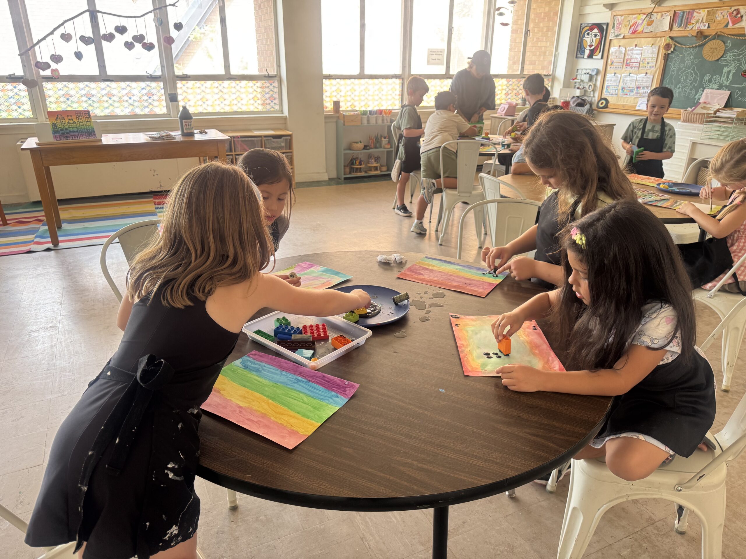 First-grade students creating colorful artwork together