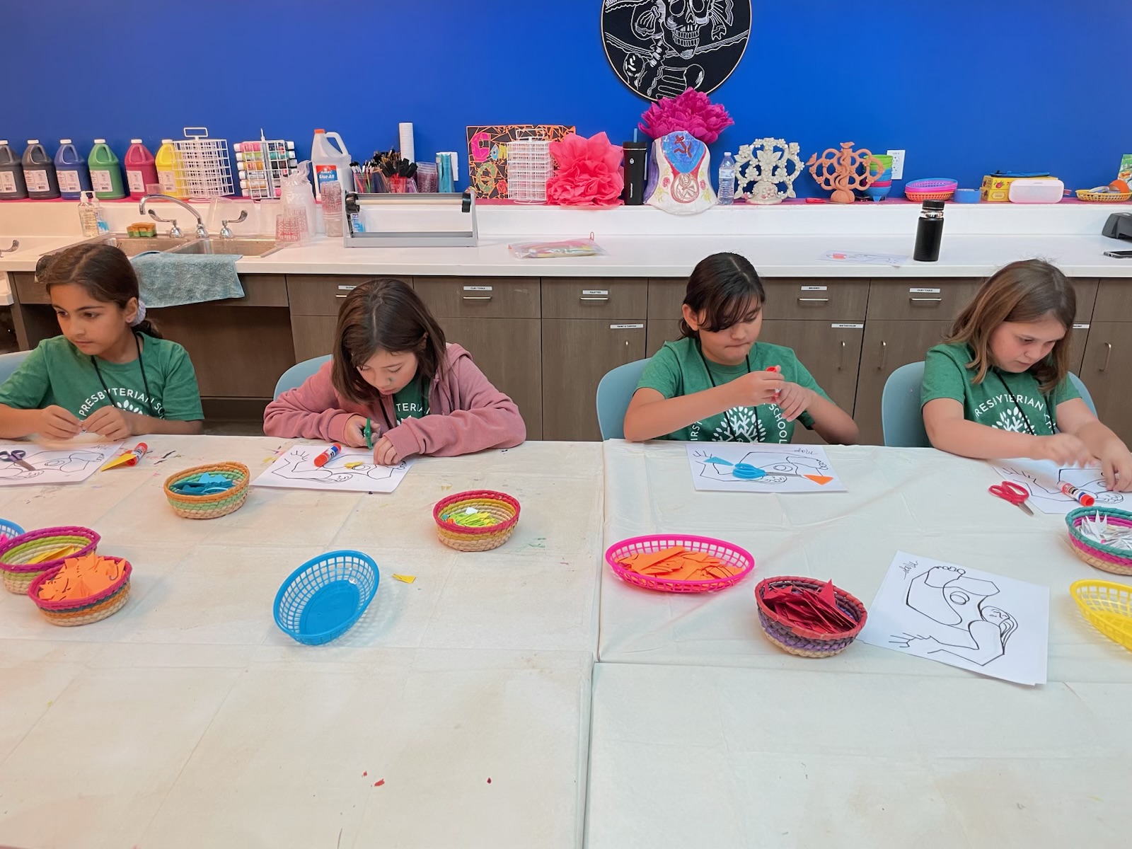 Elementary students working with paper and art materials in the classroom.